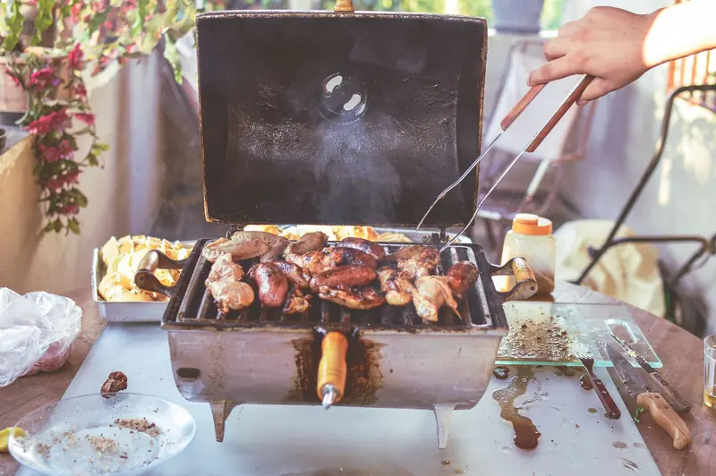 Grilled meats and vegetables cooking on an outdoor barbecue grill. Perfect for summer gatherings