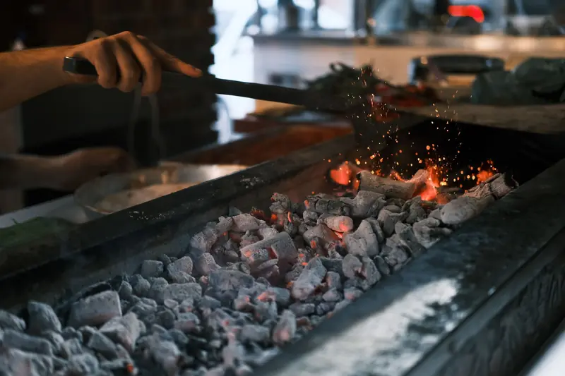 Close-up of glowing coals on a grill being prepared for a barbecue in Diyarbakır, Turkey